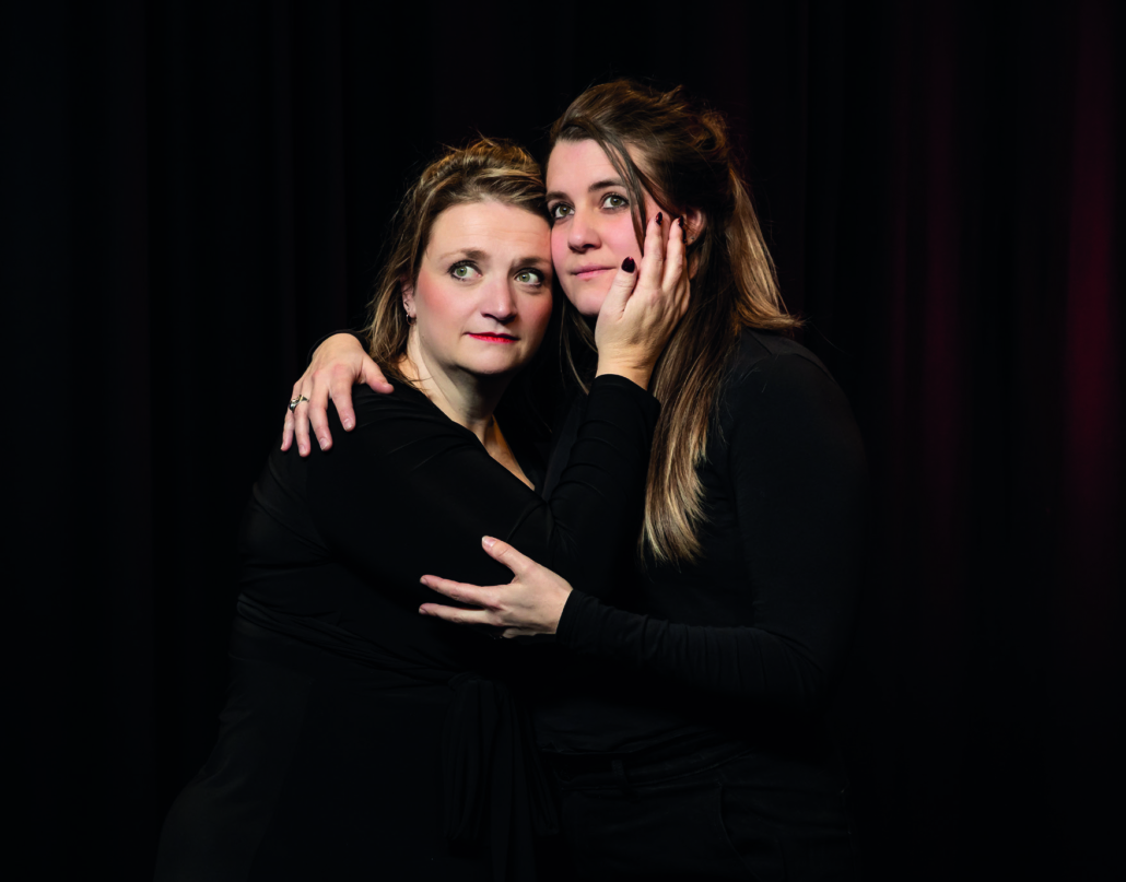 Twee spelers van Theatergroep PIT in een innige omhelzing voor een zwart doek
