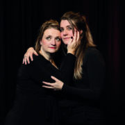 Twee spelers van Theatergroep PIT in een innige omhelzing voor een zwart doek