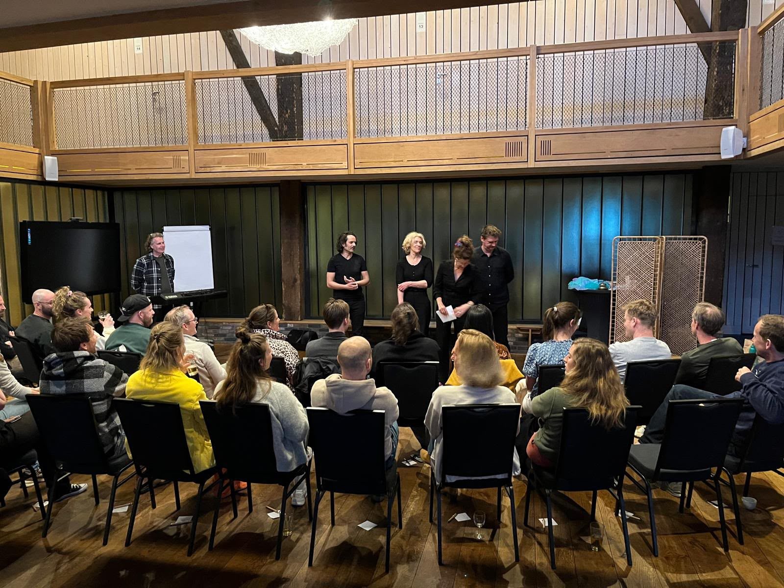 Vier spelers en een muzikant staan aan het begin van de avond voor de zaal.