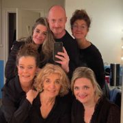 Zeven spelers van Theatergroep PIT maken een selfie in de verlichte kleedkamerspiegel, klaar voor een optreden
