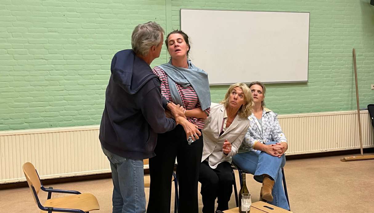 Vier spelers van Theatergroep PIT improviseren tijdens een training in wijkcentrum Villa Nova een scène over ouders en twee dochters