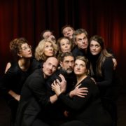 Spelers van Theatergroep PIT kijken samen omhoog voor een rood theaterdoek